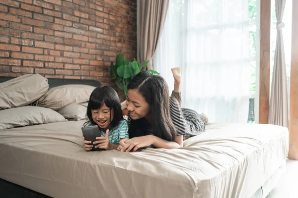 Niño jugando juego con la hermana en el teléfono inteligente — Foto de Stock