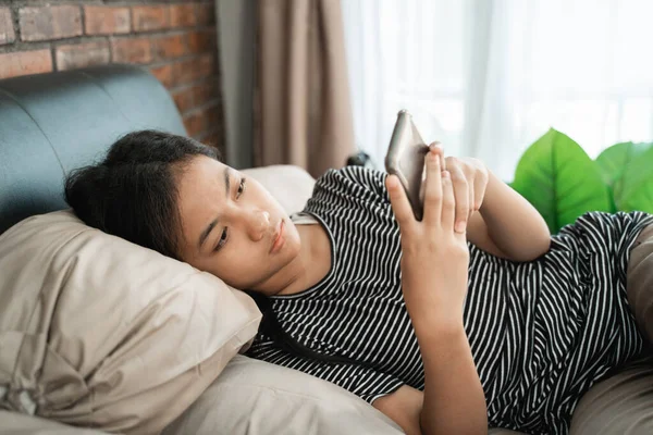 Tonåring asiatisk flicka känner sig deprimerad när du använder telefon — Stockfoto