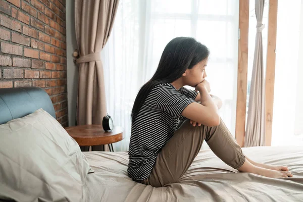 Triste adolescente sentado na cama — Fotografia de Stock