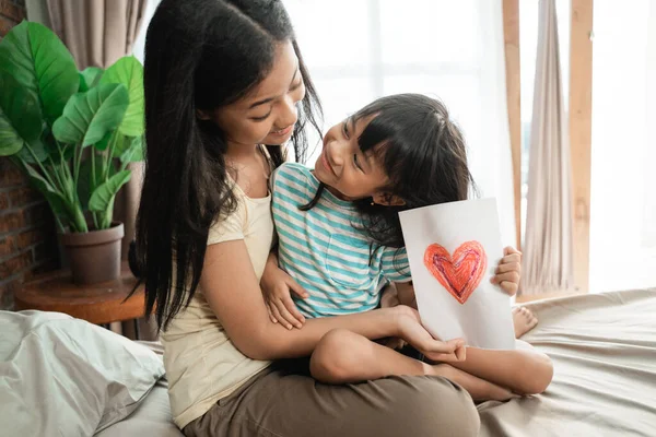 Hermana dando sorprendida tarjeta de amor — Foto de Stock