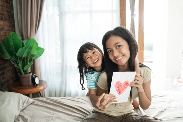 Hermana dando sorprendida tarjeta de amor — Foto de Stock