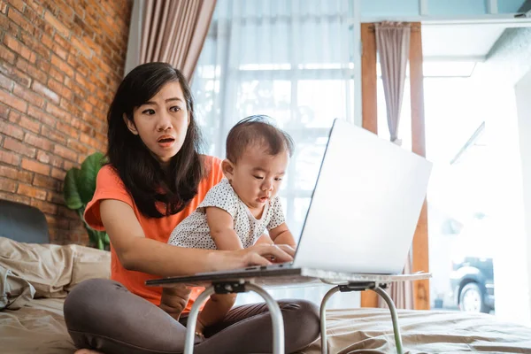 Asian woman working while taking care children — Stock Photo, Image