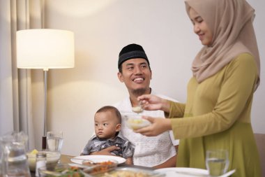 Kadın kocasına yemek servisi yapıyor.