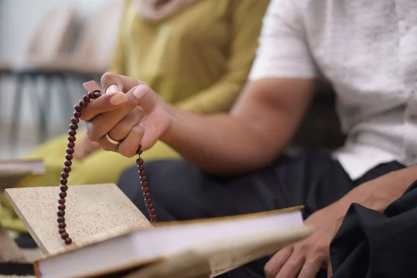 Mano sosteniendo cuentas de oración contando — Foto de Stock