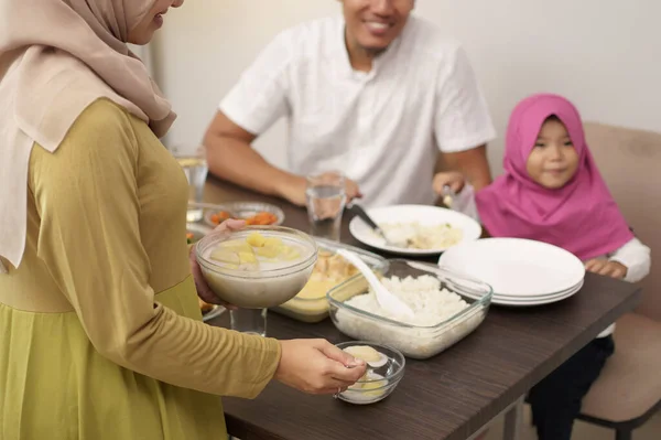Moslim moeder serveert wat eten voor familie — Stockfoto