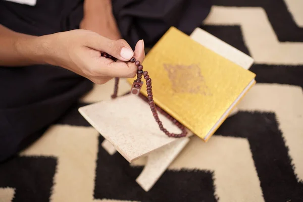 Reading holy quran and counting on prayer beads — Stock Photo, Image