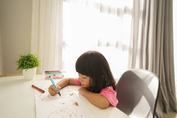Asiatisk lille barn tegning hjemmefra - Stock-foto