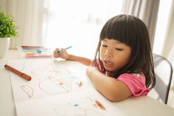 Asiatisk lille barn tegning hjemmefra - Stock-foto