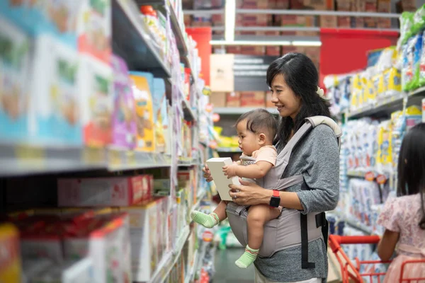 Mãe compra produto de bebê com filha — Fotografia de Stock