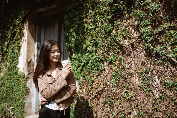 Mujer caminando mientras sostiene una taza de café — Foto de Stock