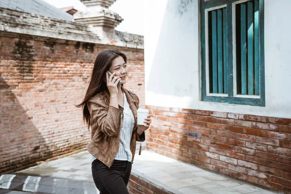 Nő beszél telefonon séta közben a városban — Stock Fotó