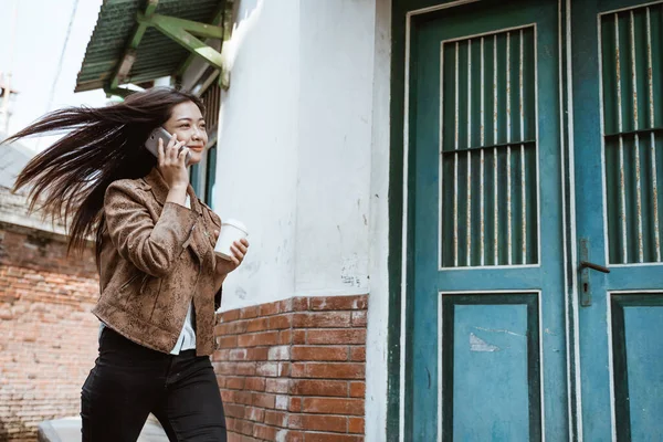 Mujer hablando por teléfono mientras camina por la ciudad — Foto de Stock