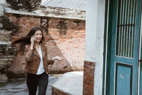 Nő beszél telefonon séta közben a városban — Stock Fotó