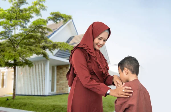 Мать мусульманского сына пожимать и целовать руку — стоковое фото