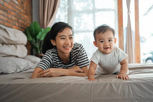 Moeder kijken naar haar baby kruipen — Stockfoto