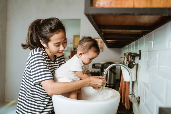 Matka pomoci její dítě umýt ruku — Stock fotografie