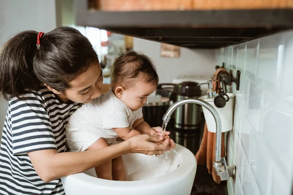 Madre ayudar a su bebé a lavarse la mano — Foto de Stock