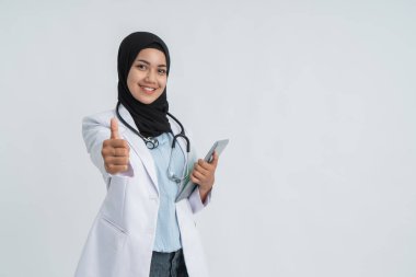 Müslüman kadın doktor baş parmağını gösteriyor.