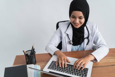 Müslüman Asyalı kadın doktor çalışıyor.