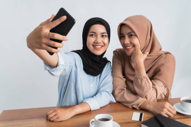 İki müslüman arkadaş selfie çekiyor.