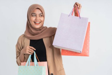 Müslüman kadın elinde kese kağıdıyla alışveriş yapıyor.