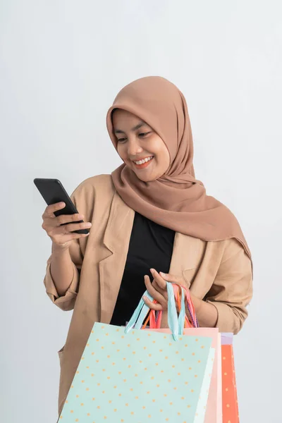 Muslimische Frau beim Einkaufen hält Handy in der Hand — Stockfoto