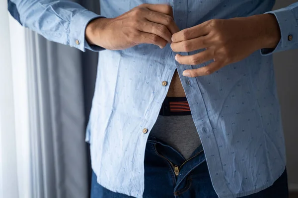 Mannen knopen blauwe shirts op werkdagen in een kamer — Stockfoto