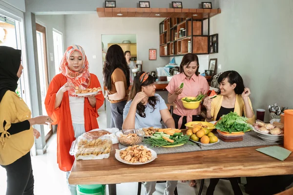 Wanita dengan teman mempersiapkan beberapa makanan untuk makan malam — Stok Foto