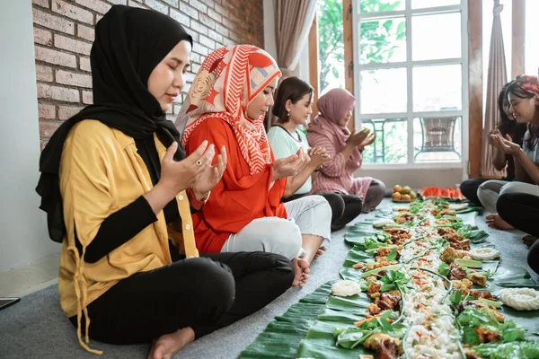 Мусульманская женщина молится перед обедом — стоковое фото