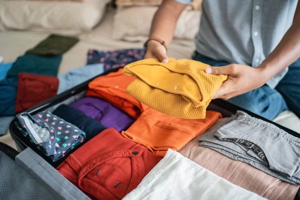 Jovem preparando suas roupas colocar na mala — Fotografia de Stock