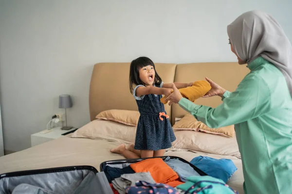 Dochter geeft kleren aan haar moeder bij de voorbereiding van kleding — Stockfoto