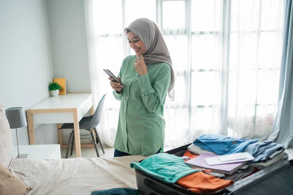 Wanita muslim asia melihat jadwal keberangkatan melalui ponsel — Stok Foto
