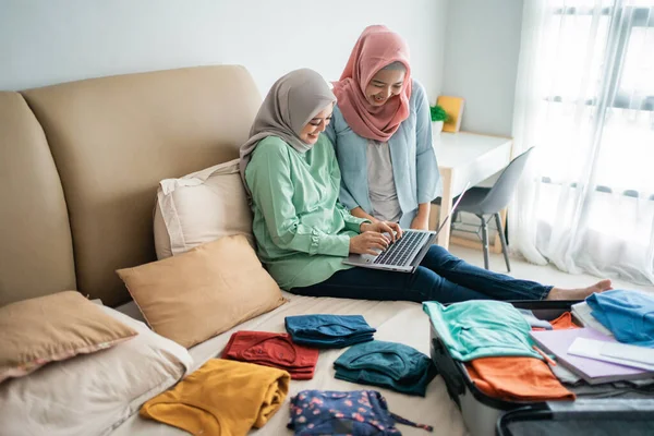 Zwei muslimische Frauen suchen per Online-Anwendung per Laptop nach Abflugplänen — Stockfoto