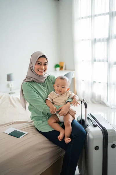 Muslimische asiatische Mütter tragen ihre Babys im Sitzen auf dem Bett — Stockfoto