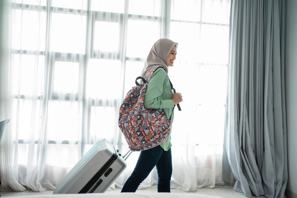 Beleza jovem hijab viajante andar e carregando seu saco e segurando mala — Fotografia de Stock