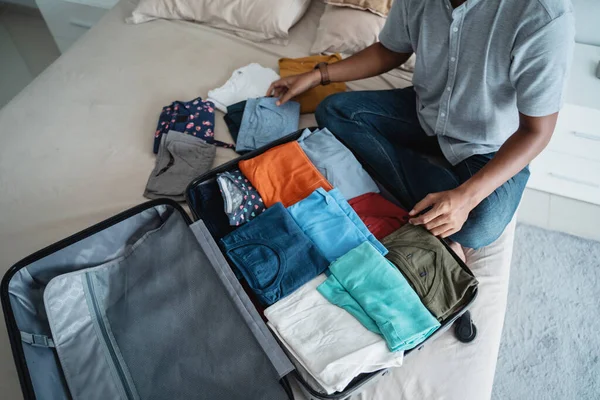 Jovem preparando suas roupas colocar na mala — Fotografia de Stock