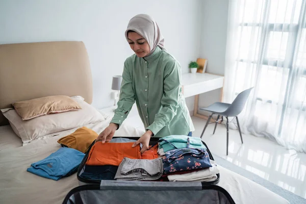 Gyönyörű muszlim nők készíti ruhák kell tenni egy bőröndbe — Stock Fotó