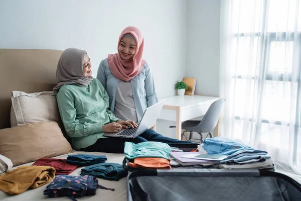 Zwei Hidschab-Frauen prüfen Abflugpläne per Online-Antrag — Stockfoto