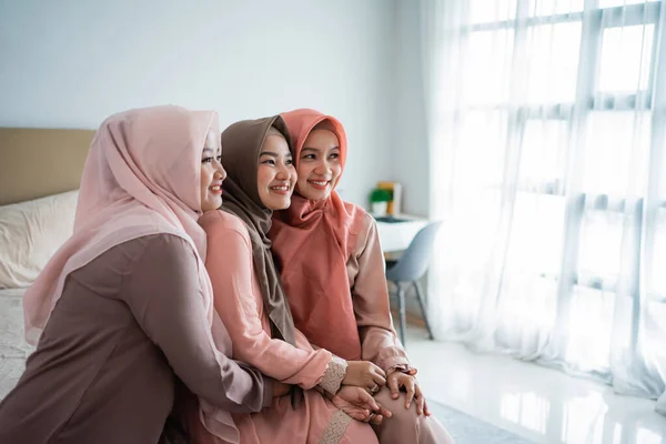 Perempuan muslim asia menikmati mengobrol sambil duduk di tempat tidur — Stok Foto