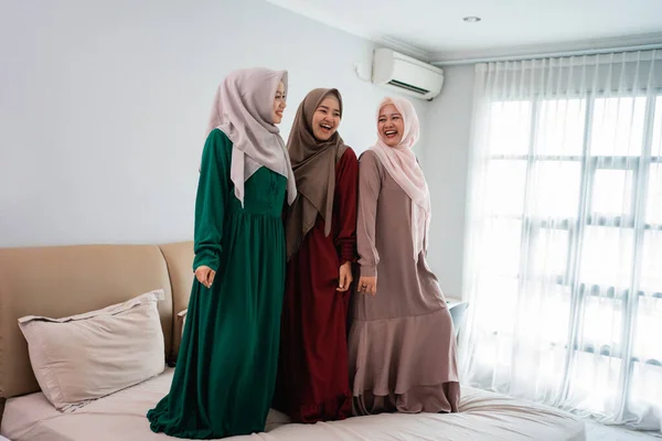 Bersenang-senang sementara menghabiskan waktu tiga wanita moslem berdiri di tempat tidur — Stok Foto