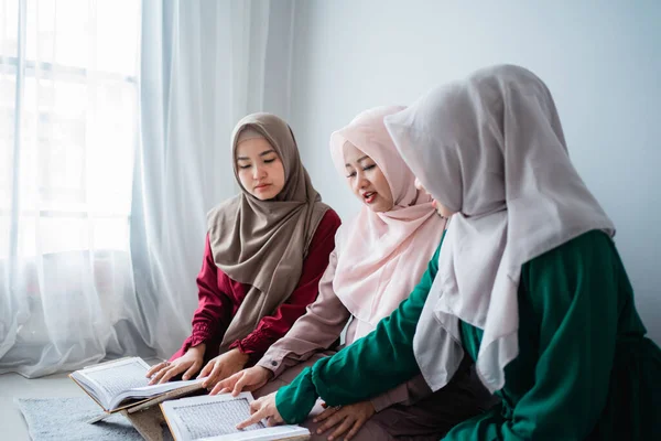 Три азиатских мусульманки читать и изучать священную книгу Аль-Корана вместе — стоковое фото