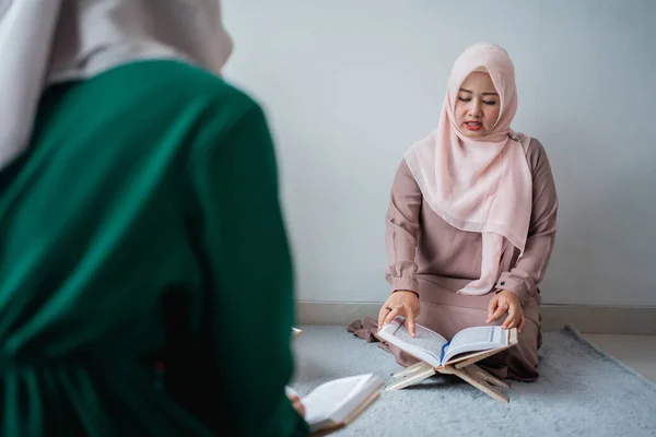 히잡을 쓰고 있는 두 젊은 여성 이 함께 코란 경전을 읽고 있습니다 — 스톡 사진