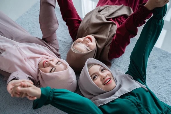 Grupo de amigas musulmanas sonrieron mientras yacían sobre el colchón —  Fotos de Stock