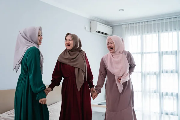 Hidžáb ženy se svými přáteli stojící v posteli v ložnici — Stock fotografie