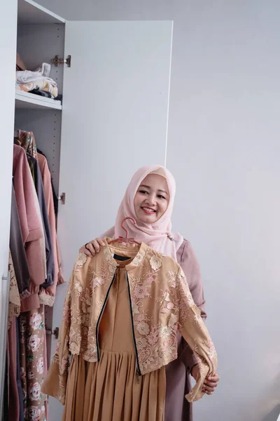 Asian hijab women measure a new gamis by the body