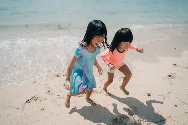 Dos poco asiático niñas jugando en la playa —  Fotos de Stock