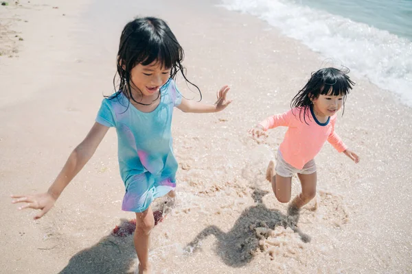 ビーチで遊んでいる2人の小さなアジアの女の子 — ストック写真