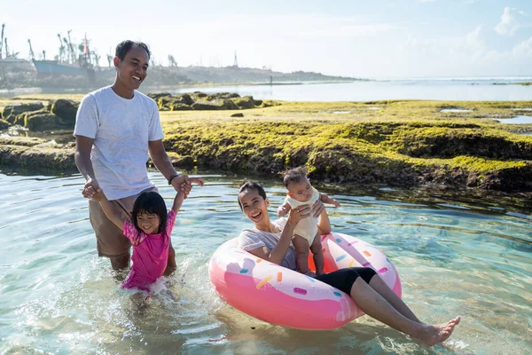 Famille heureuse jouant sur la plage — Photo