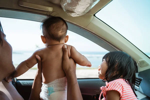 Bebé desnudo quiere mirar por la ventana del coche — Foto de Stock