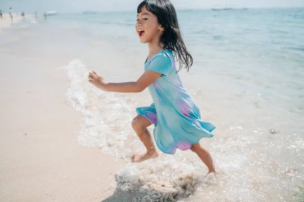 Kleine Mädchen rennen und lachen am Strand — Stockfoto